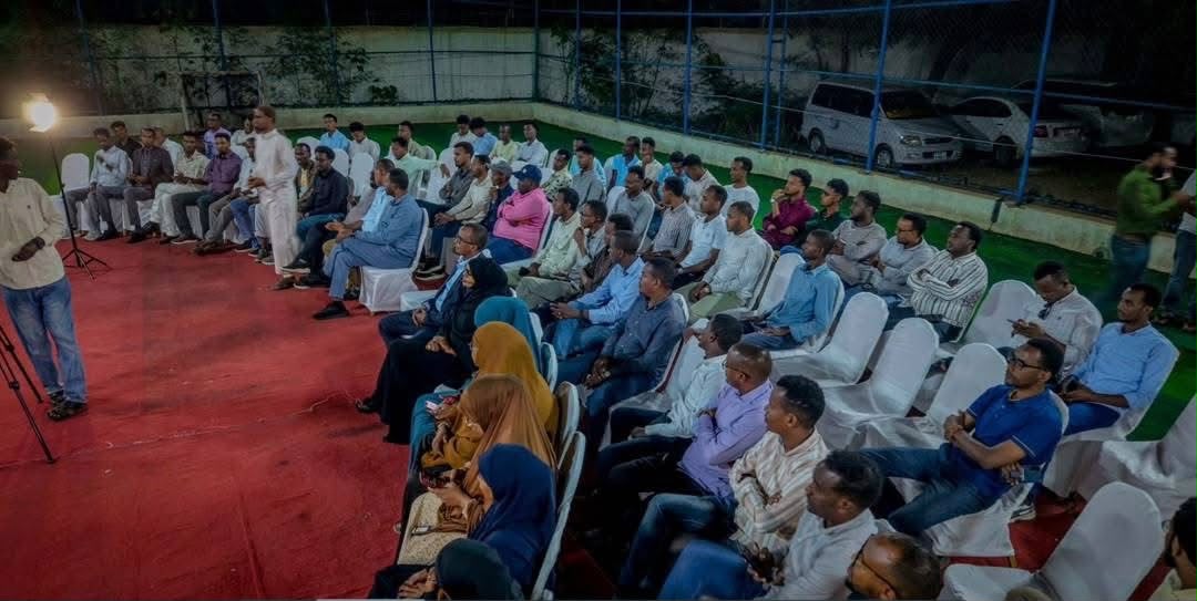 Participants seated at the discussion, with a participant standing to speak